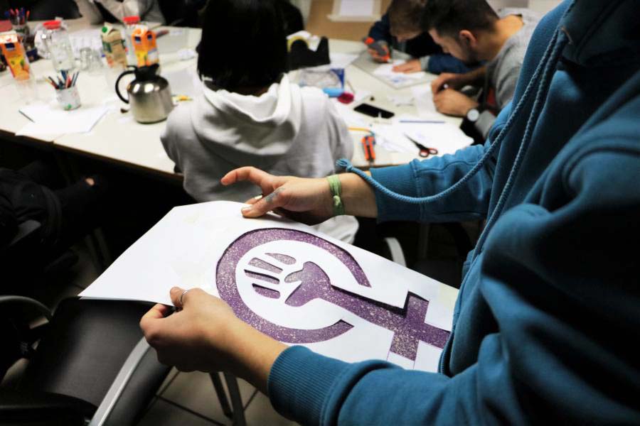 Eine Frau hält ein Bild des Symbols von Frauenpower in der Hand.